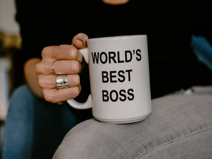 woman in black v neck shirt holding white ceramic mug